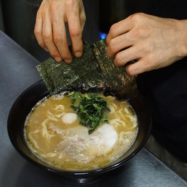 ラーメンにのりを盛り付けている様子
